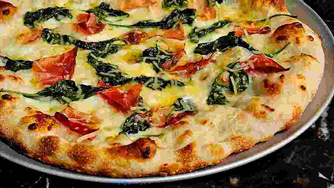 white pizza with speck and spinach